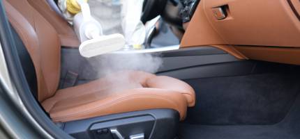 man-protective-suit-cleaning-car-interior-with-steamer-closeup-scaled-1.jpg